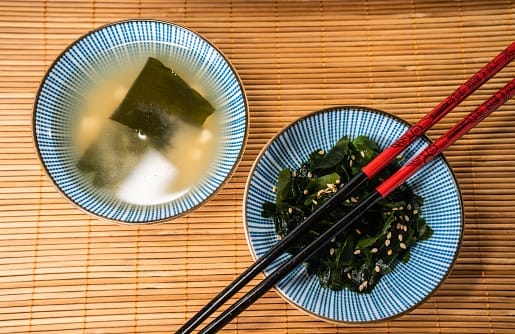 Shot from above of miso soup and wakame seaweed salad